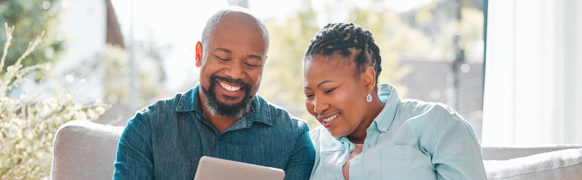 Couple uses device to look at investments.