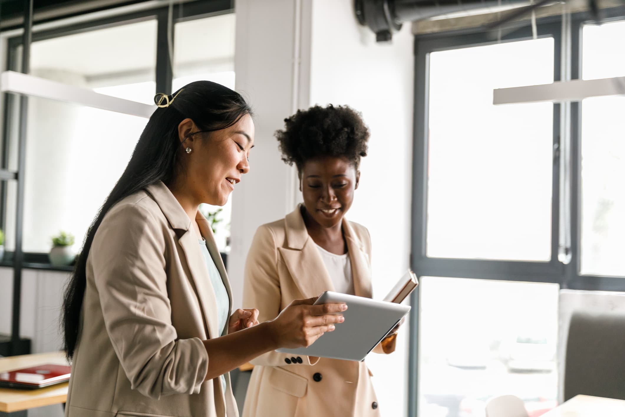 Two Women Meeting with Tablets in Bright Office