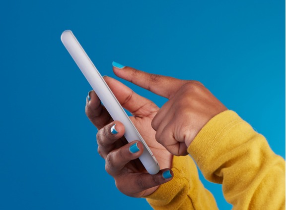 Close-up of Hands Using Phone Against Blue Background