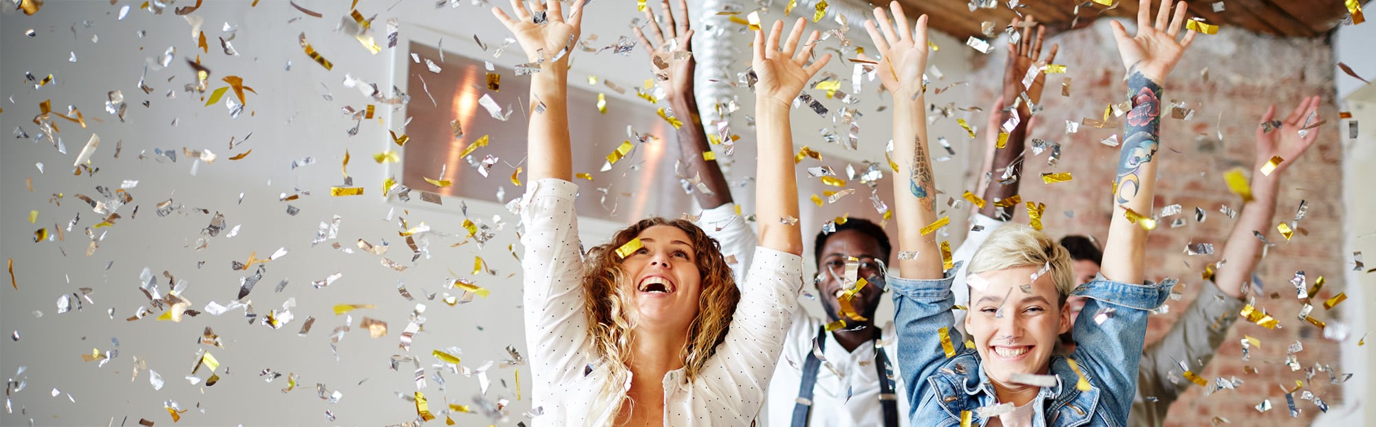 People Celebrating with Hands Raised and Confetti Falling