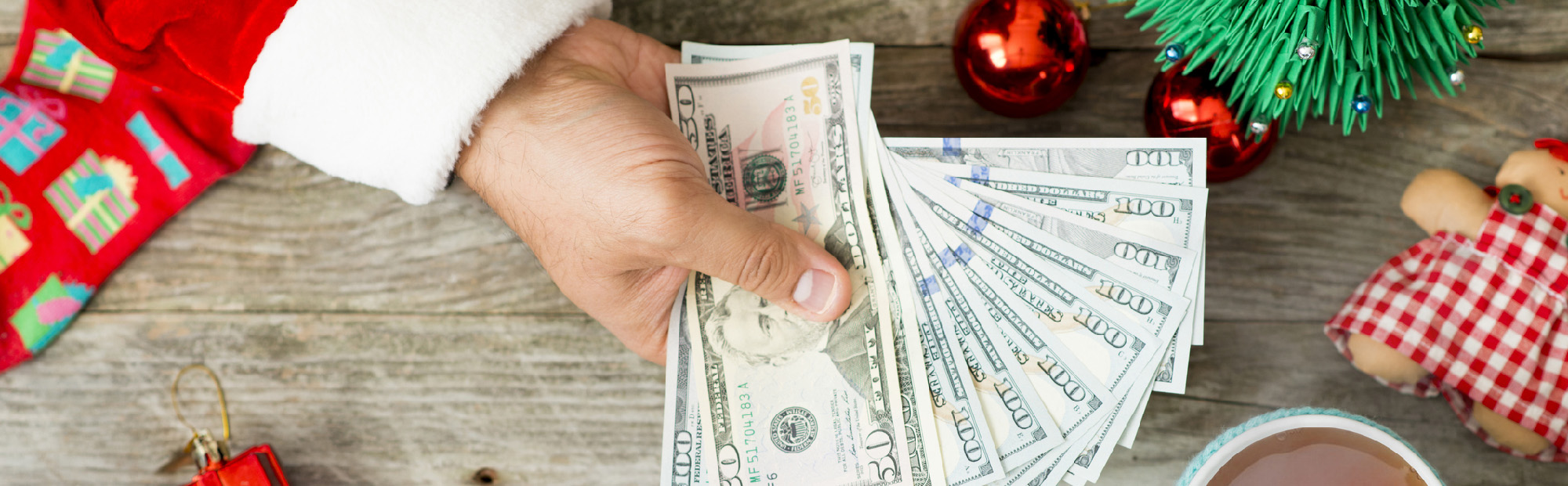 Red-Sleeved Hand Holding Money with Holiday Trinkets