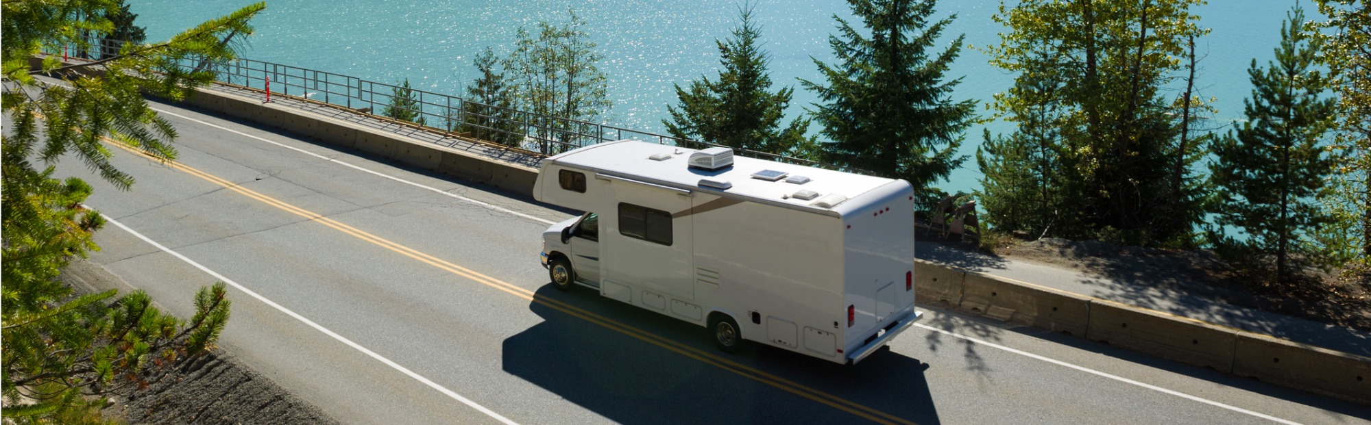 RV drives along a lake