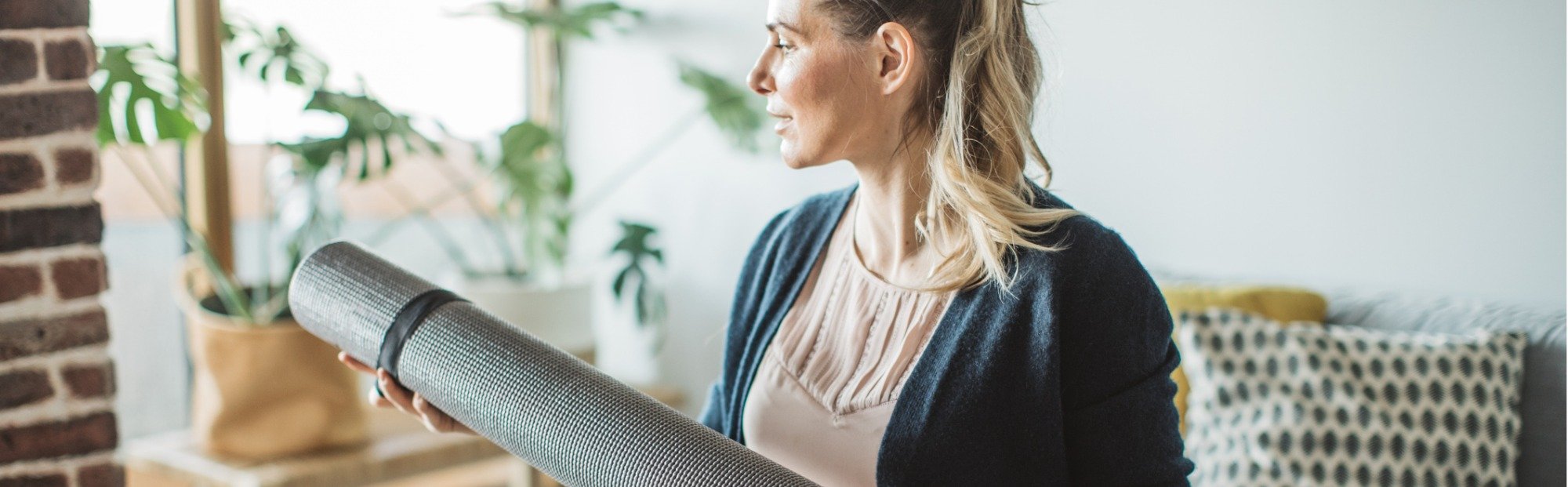 Woman Unpacking Yoga Mat from Shipping Box on Sunny Day
