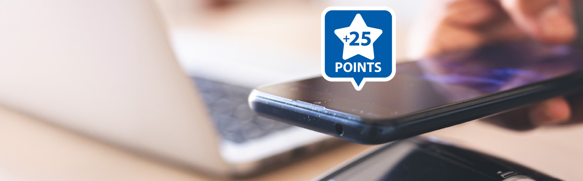 Close Up of Phone at Terminal with Graphic of 25 Points in a Star and Laptop in Background