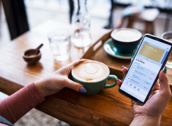 shot-of-young-woman-managing-bank-account-on-smartphone-at-cafe