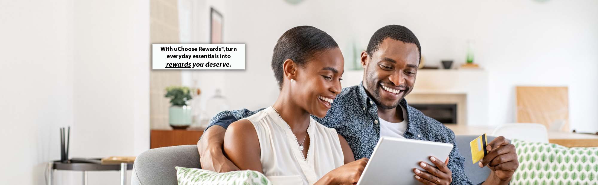 Smiling Couple Using Credit Card and Tablet