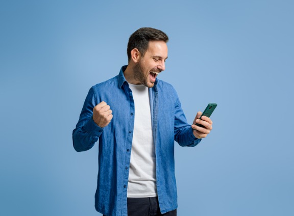 Happy guy in blue with cell phone