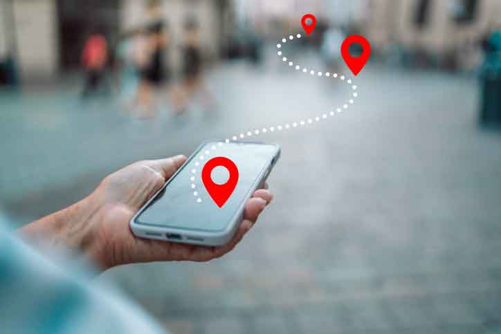 Hand Holding Smartphone and Location Tags Leaping Off the Screen